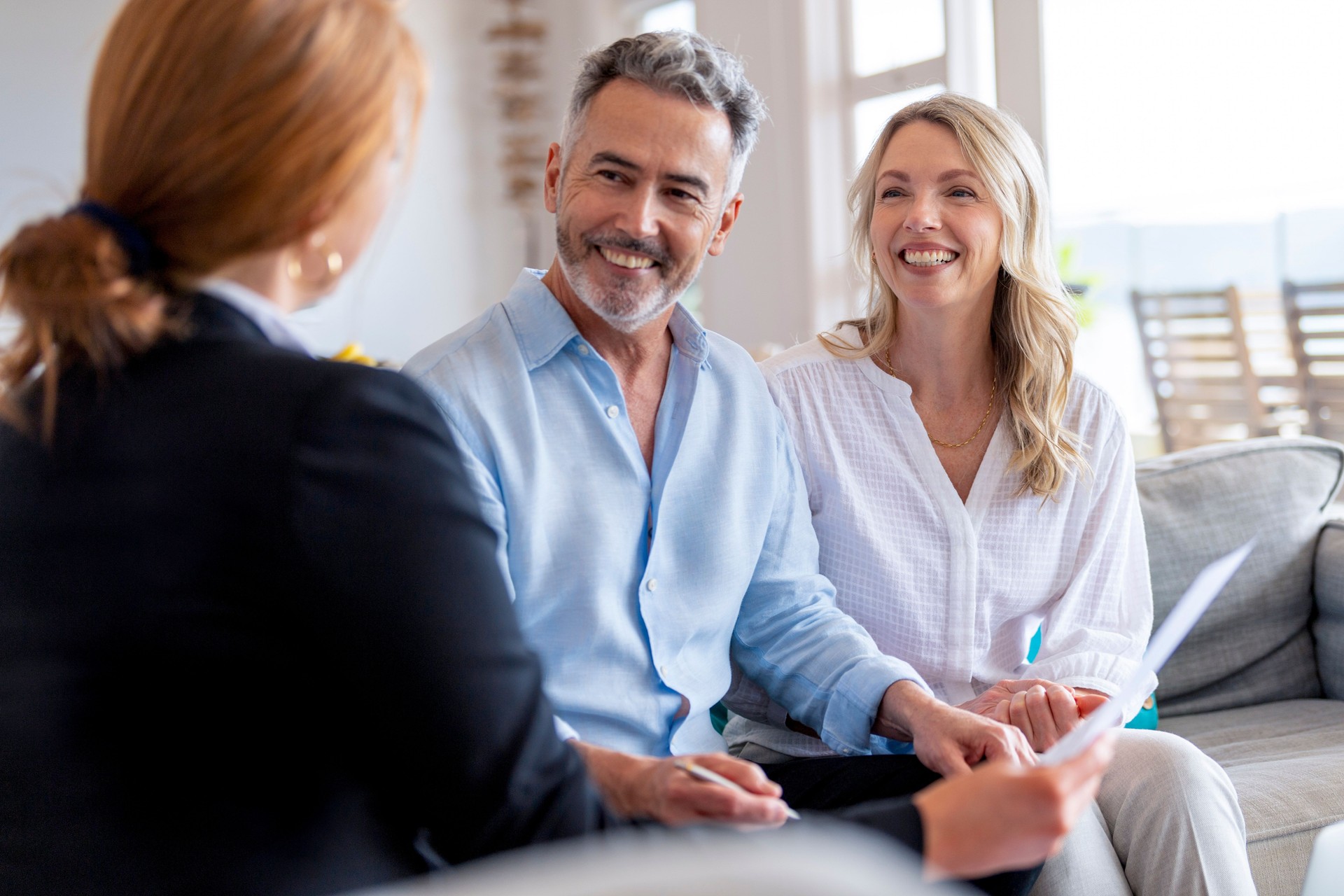 Happy mature couple meeting investments and financial advisor at home.